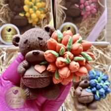 Chocolate bear holding flowers